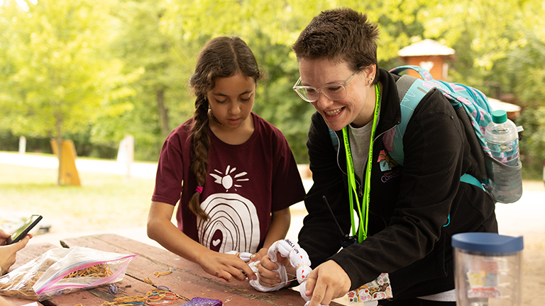 camp director helping camper with tie-dye