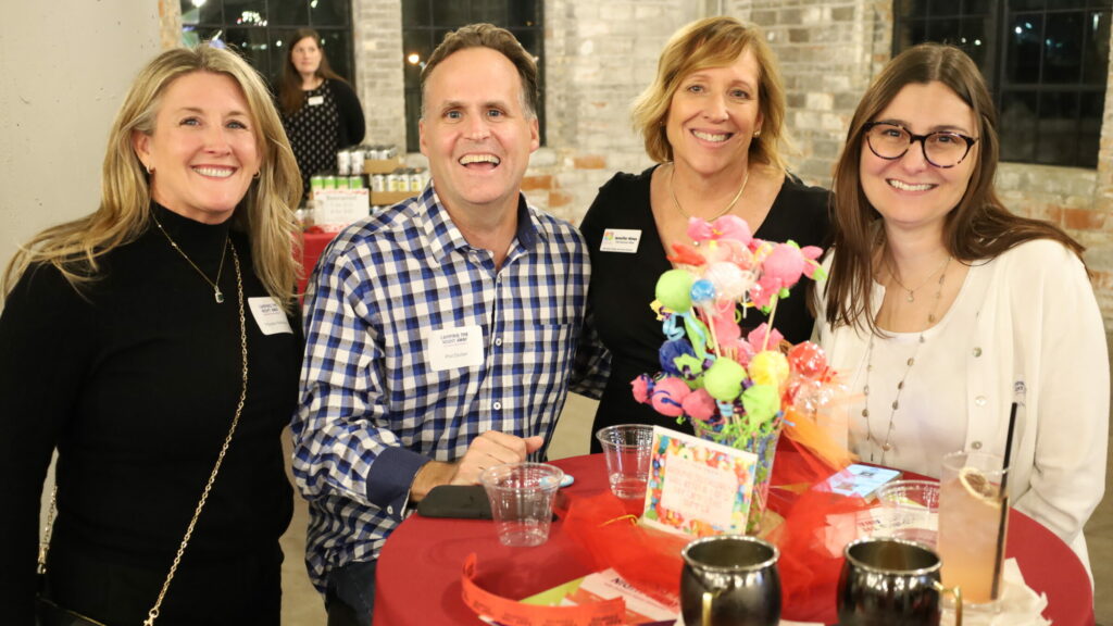 Four guests around a high top table decorated with candy