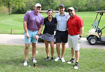 go gold and golf team of four posing on the course
