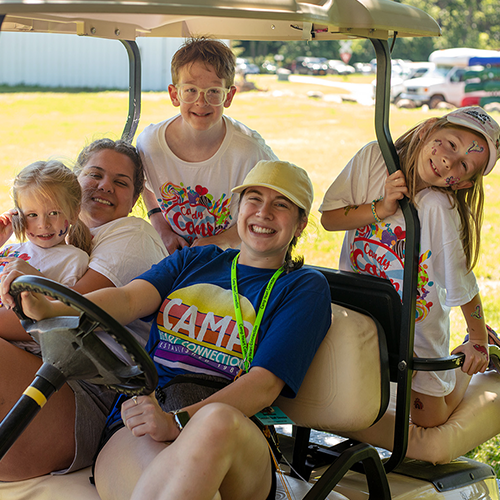 volunteers and campers on golf cart