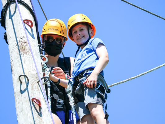 boy at the top of the zipline tower