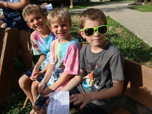 three friends hang out before a campfire at camp