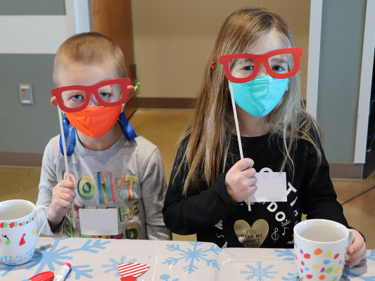 kids with photo prop glasses at holiday dropoff